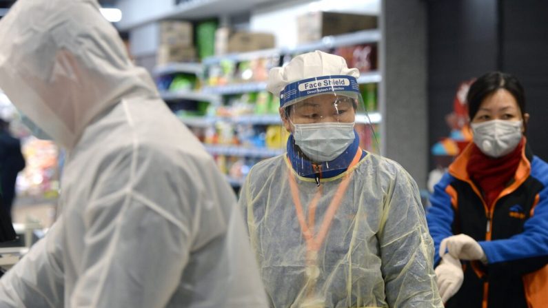 Un membre du personnel portant un masque et une combinaison de protection travaille dans un supermarché de Wuhan, l'épicentre de l'épidémie d'un nouveau coronavirus, dans la province centrale du Hubei en Chine, le 10 février 2020. (STR/AFP via Getty Images)