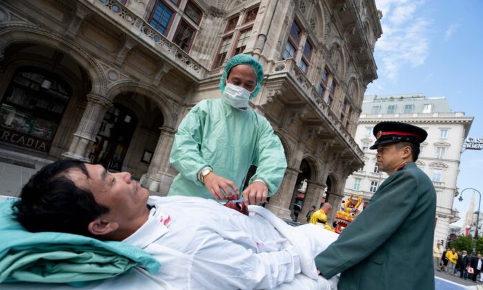 Des pratiquants du Falun Gong reconstituent le prélèvement forcé d'organes des prisonniers de conscience effectué par le régime chinois lors d'une manifestation à Vienne, en Autriche, le 1er octobre 2018. (Joe Klamar/AFP via Getty Images)