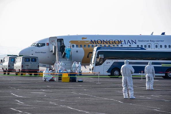 -Un citoyen mongol descend d'un avion pour son évacuation de la ville chinoise de Wuhan à Oulan-Bator, la capitale de la Mongolie, le 1er février 2020. Photo de BYAMBASUREN BYAMBA-OCHIR / AFP via Getty Images.