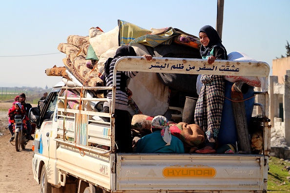 Des Syriens déplacés transportent leurs effets personnels dans un camion dans la province d'Idlib, dans le nord-ouest de la Syrie, le 3 mars 2020, près de la ville d'Adwan. (Photo : IBRAHIM YASOUF/AFP via Getty Images)