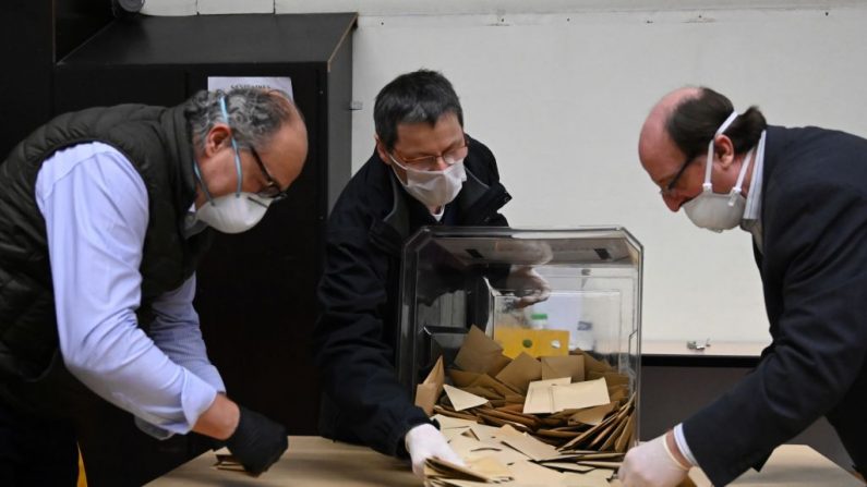 TOPSHOT - Des travailleurs électoraux portant des masques de protection et des gants en plastique effectuent le dépouillement des bulletins de vote après le premier tour des élections municipales de France dans un bureau de vote à Strasbourg, dans l'est de la France, le 15 mars 2020. - Les électeurs français ont voté aux élections municipales du 15 mars, qui devraient connaître la plus faible participation depuis des décennies, après que le nombre croissant de coronavirus a obligé le gouvernement à fermer tous les bars, restaurants et autres commerces non essentiels afin de limiter l'épidémie.  (Photo by FREDERICK FLORIN/AFP via Getty Images)