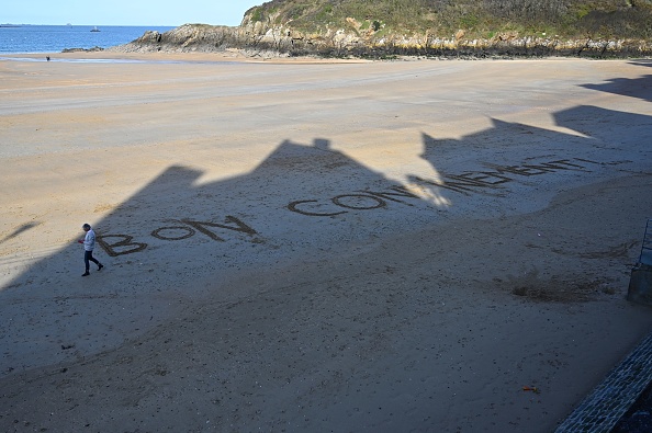 Une femme se promène sur la plage de Saint-Lunaire (Ille-et-Vilaine) le 17 mars 2020, alors que le confinement a été décrété pour tout le monde en France. DAMIEN MEYER/AFP via Getty Images)