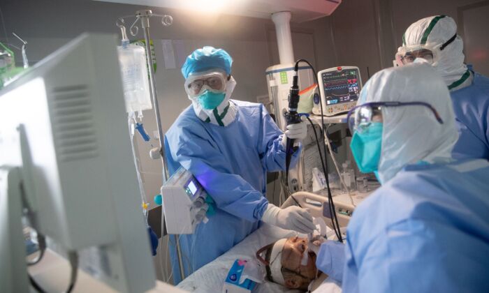 Le personnel médical traite des patients COVID-19 dans un hôpital de Wuhan, en Chine, le 19 mars 2020. (STR/AFP via Getty Images)