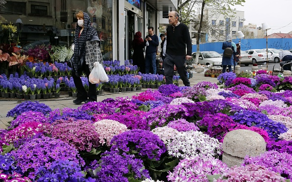 Des passants, certains portant des masques protecteurs, achètent des articles traditionnels avant Nowruz, la célébration nationale du Nouvel An de 2 semaines, au Tajrish Bazaar dans la capitale Téhéran le 19 mars 2020. Photo par STR / AFP via Getty Images.