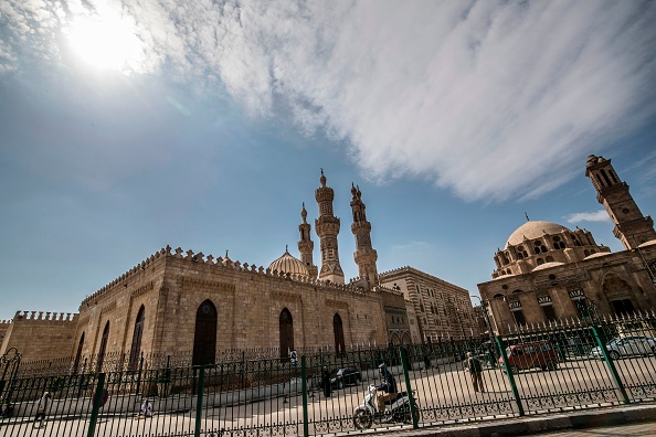 -Quelques personnes marchent à proximité de la mosquée fermée d'Al-Azhar dans la capitale égyptienne, Le Caire, le 20 mars 2020. Photo par Khaled DESOUKI / AFP via Getty Images.