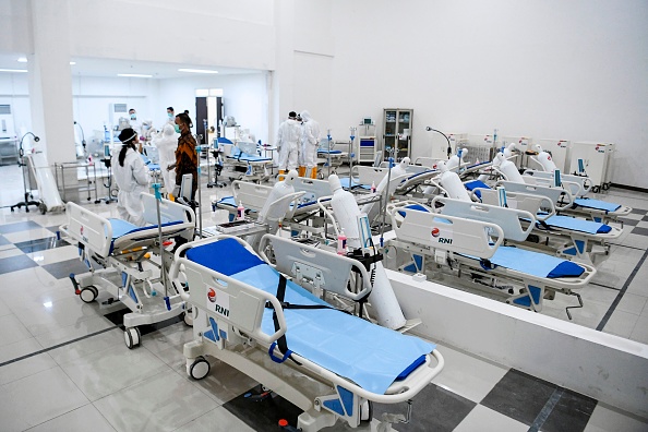 -Le personnel médical indonésien prépare une chambre pour les patients dans le village des athlètes des Jeux asiatiques de 2018 qui a été converti en hôpital pour les patients atteints de coronavirus à Jakarta le 23 mars 2020. Photo de Hafidz Mubarak A / POOL / AFP via Getty Images.