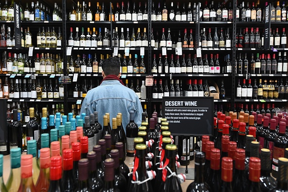 -Un mécène se tient devant une étagère pleine de bouteilles de vin et de Liqueur le 20 mars 2020 dans le quartier de Brooklyn à New York. Les ventes d'alcools ont explosé à New York depuis qu'une urgence nationale a été déclarée et que New York a fermé tous ses théâtres, bars et restaurants. Photo par ANGELA WEISS / AFP via Getty Images.