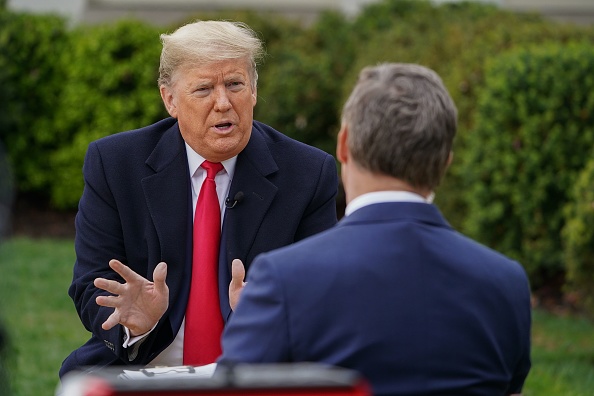 Le président américain Donald Trump parle avec l'hôte de l'émission de Fox News,  Bill Hemmer lors d'une réunion au Rose Garden de la Maison Blanche à Washington, DC, le 24 mars 2020. (Photo : MANDEL NGAN/AFP via Getty Images)