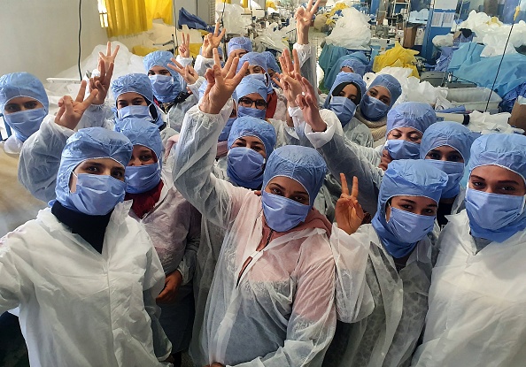 Des femmes tunisiennes  qui travaillent à la production de masques médicaux dans l'usine de la société Consomed dans le centre ville de Kairouan en Tunisie. (Photo :-/CONSOMED/AFP via Getty Images)