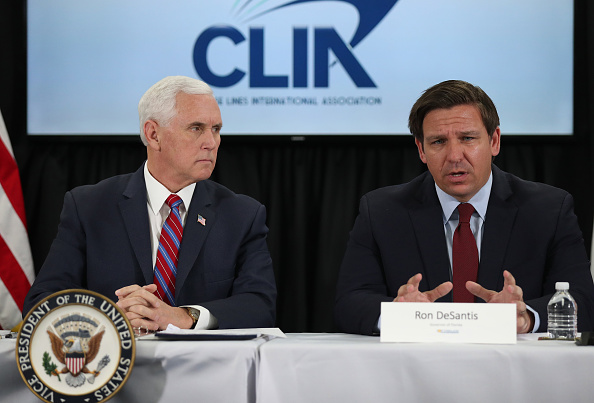 Le vice-président Mike Pence écoute le discours du gouverneur de la Floride, Ron DeSantis, lors d'une discussion tenue à Port Everglades sur d'éventuels problèmes de coronavirus que les dirigeants de compagnies de croisières rencontrent le 7 mars 2020 à Fort Lauderdale, en Floride. (Photo : Joe Raedle/Getty Images)