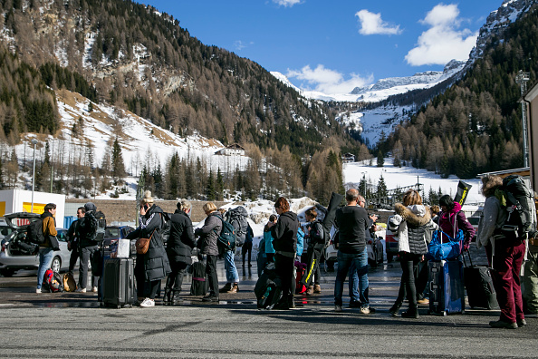 -Des Allemands attendent un bus du côté autrichien au passage frontalier entre l'Autriche et l'Italie après leur arrivée au col du Brenner, près de Matrei am Brenner le 11 mars 2020. Le chancelier autrichien Sebastian Kurz a annoncé hier que l'Autriche refusait les personnes arrivant d'Italie, à l'exception de celles détenant un certificat médical. Photo de Jan Hetfleisch / Getty Images.