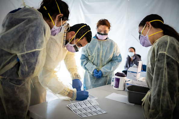 -Des tentes installées pour trier les éventuels patients du virus du PCC, à l'extérieur avant d'entrer dans la zone principale du service des urgences de l'hôpital St.Barnabas dans le Bronx le 24 mars 2020 à New York. Photo de Misha Friedman / Getty Images.