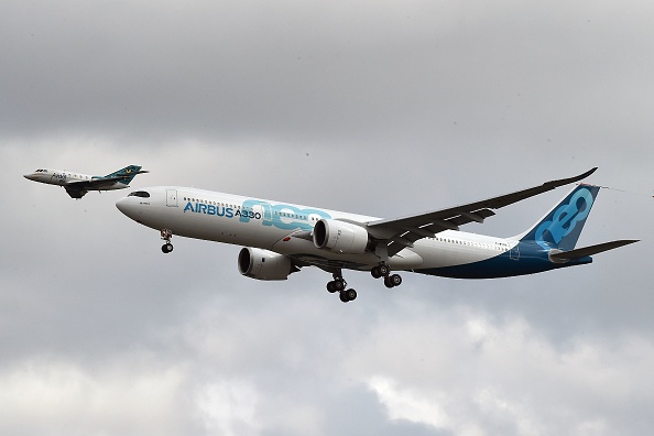 -Un nouvel Airbus A330neo s'apprête à atterrir après son premier vol, un hélicoptère filme son atterrissage, le 19 octobre 2017, à l'aéroport de Toulouse-Blagnac, près de Toulouse. Photo PASCAL PAVANI / AFP via Getty Images.