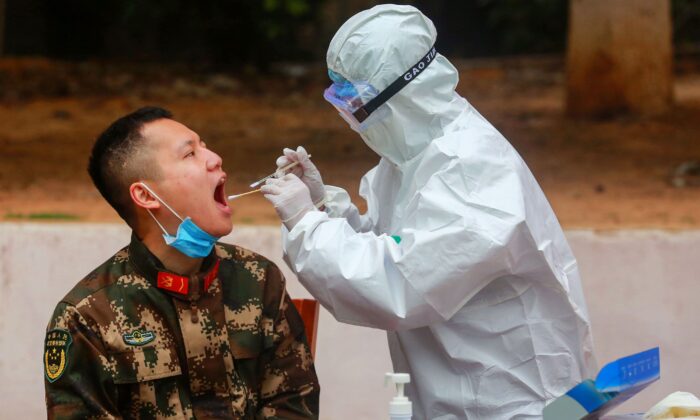 Un membre du personnel médical prélève des échantillons auprès d'agents de la police paramilitaire chinoise pour les soumettre au test COVID-19, à Shenzhen, en Chine, le 11 février 2020. (STR/AFP via Getty Images)