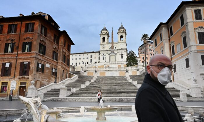 Un homme portant un masque de protection passe sur la Place d'Espagne (Piazza di Spagna) déserte au centre de Rome le 12 mars 2020. (ALBERTO PIZZOLI/AFP via Getty Images)