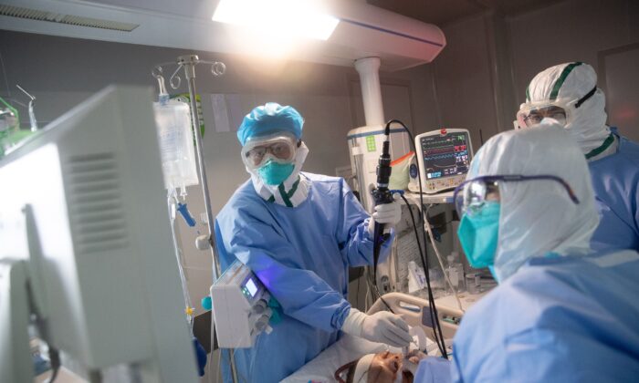 Le personnel médical traite un patient atteint de coronavirus dans un hôpital de Wuhan, dans la province du Hubei en Chine, le 19 mars 2020. (STR/AFP via Getty Images)