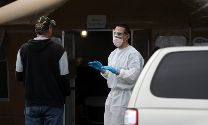 Un pompier examine un homme qui fait la queue pour obtenir un test COVID-19 dans une clinique de contrôle gratuit publique à Hayward, en Californie, le 24 mars 2020. (Justin Sullivan/Getty Images)