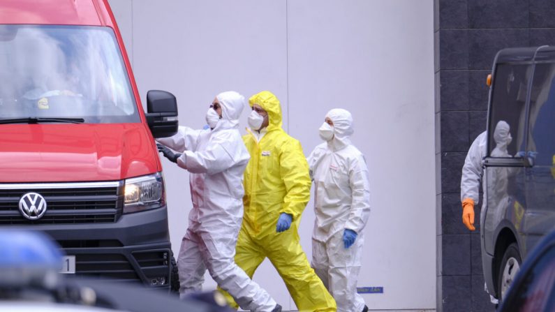 Des membres de l'unité militaire d'urgence donnent des instructions à un chauffeur de camionnette devant le Palacio de Hielo (patinoire), qui a été temporairement transformé en morgue avec des centaines de corps de victimes du virus du PCC, à Madrid le 27 mars 2020. (Xaume Olleros/Getty Images)