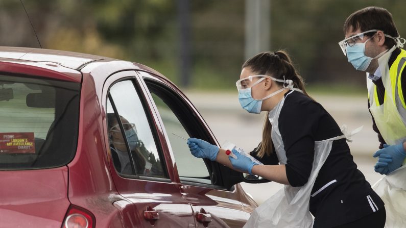 Une infirmière fait un prélèvement dans une station de test pour le covid-19 à Chessington, au Royaume-Uni, le 30 mars 2020. (Dan Kitwood/Getty Images)