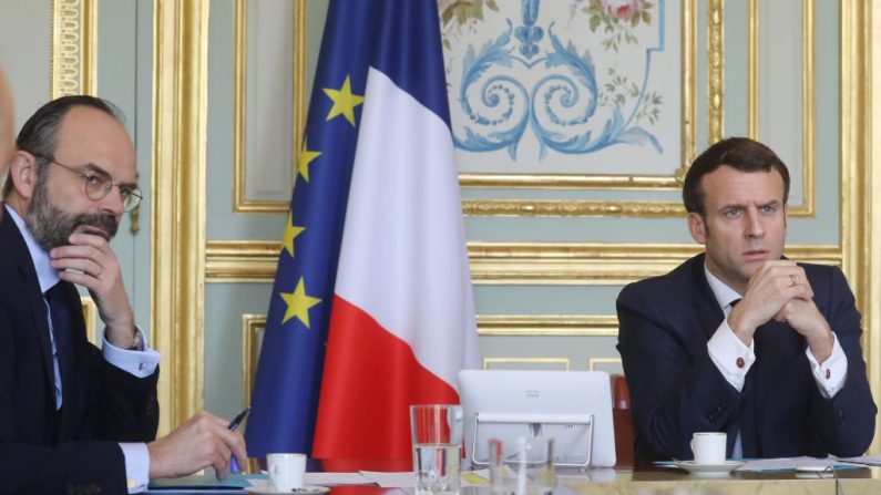 Le président français Emmanuel Macron (à droite) et le Premier ministre français Edouard Philippe participent à une vidéoconférence de la "task force économique", dans la salle de réunion présidentielle verte, au Palais de l'Elysée, avec des responsables économiques français et des membres du gouvernement préoccupés par l'épidémie de coronavirus et les mesures de confinement, le 19 mars 2020, à Paris. (Photo by LUDOVIC MARIN/POOL/AFP via Getty Images)