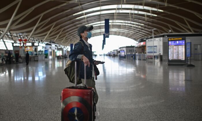 Un passager regarde un écran à l'aéroport international de Shanghai Pudong à Shanghai, en Chine, le 19 mars 2020. (HECTOR RETAMAL/AFP via Getty Images)