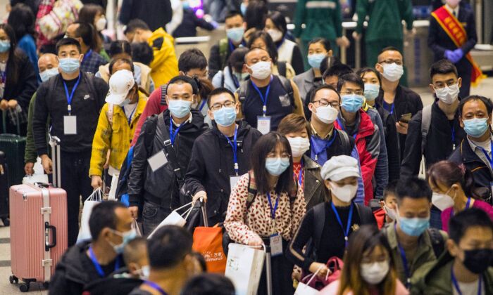 Des travailleurs migrants et leurs proches attendent le train pour Shenzhen à la gare de Yichang East Station à Yichang, dans la province centrale du Hubei, en Chine, le 23 mars 2020. (STR/AFP via Getty Images)