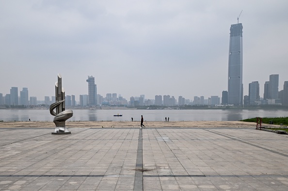 -Des personnes portant des masques faciaux marchent sur une place le long du fleuve Yangtze à Wuhan, dans la province centrale du Hubei en Chine, le 31 mars 2020. Photo par Hector RETAMAL / AFP via Getty Images.