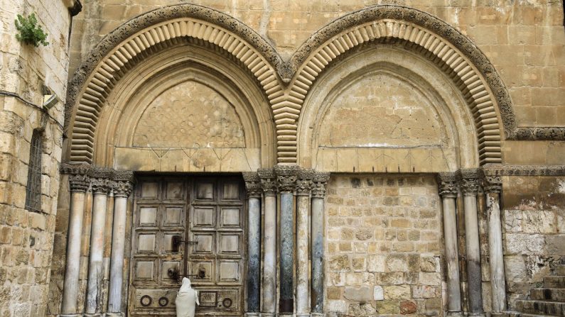 -Un pèlerin chrétien habillé en Jésus-Christ se tient devant la porte fermée de l'église du Saint-Sépulcre dans la vieille ville de Jérusalem le 10 avril 2020, marquant le Vendredi Saint, au milieu de la crise pandémique COVID-19. Tous les sites culturels de Terre Sainte sont fermés. Photo par EMMANUEL DUNAND / AFP via Getty Images