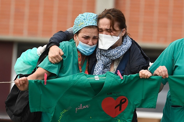 -Illustration- Un travailleur de la santé réconforte l'épouse d'Esteban, un infirmier décédé de la maladie des coronavirus à l'hôpital Severo Ochoa de Leganes, près de Madrid, le 10 avril 2020. L'Espagne avait enregistré son taux de mortalité quotidien le plus bas du nouveau coronavirus en 17 jours, mais aujourd’hui le taux est reparti à la hausse. Photo par PIERRE-PHILIPPE MARCOU / AFP via Getty Images.