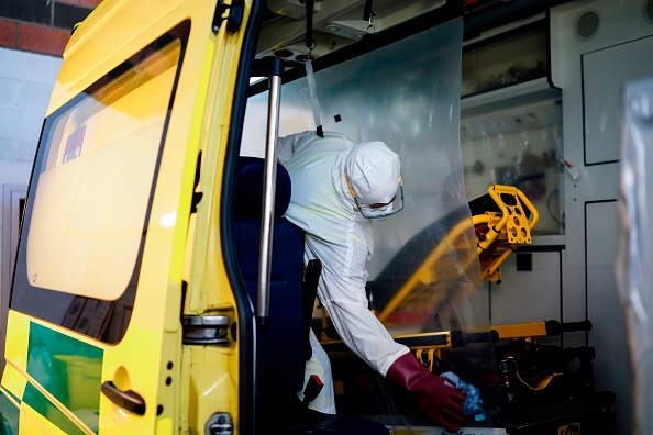 -Un pompier belge désinfecte une ambulance à la caserne des pompiers après l'évacuation d'un patient suspecté d'avoir le nouveau coronavirus, COVID-19, à Liège le 10 avril 2020. - Les pompiers aident les services d'ambulance, les hôpitaux et les médecins. Photo par kenzo tribouillard / AFP via Getty Images.