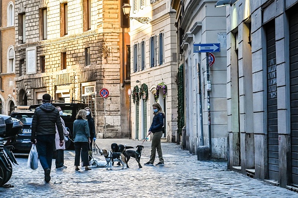 Des personnes portant un masque facial promènent leurs chiens dans le centre de Rome le 15 avril 2020, pendant le confinement du pays visant à freiner la propagation de la pandémie de COVID-19, causée par le virus de Wuhan. (Photo : ANDREAS SOLARO/AFP via Getty Images)