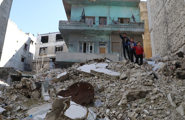 -Des enfants se tiennent au sommet des débris d'un bâtiment détruit par des frappes aériennes des forces pro-régime dans la ville d'Ariha, dans la campagne sud de la province d'Idlib, le 11 avril 2020. Photo par AAREF WATAD / AFP via Getty Images.