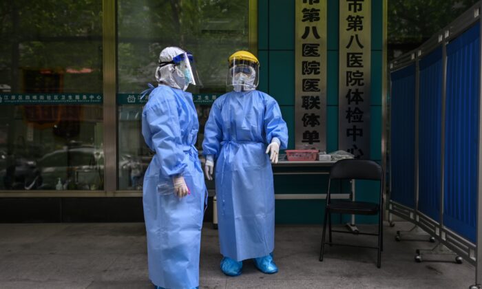 Des travailleurs médicaux sont vus prélevant des échantillons sur des personnes à tester pour le nouveau coronavirus à Wuhan, dans la province centrale du Hubei en Chine, le 16 avril 2020. (Hector Retamal / AFP via Getty Images)