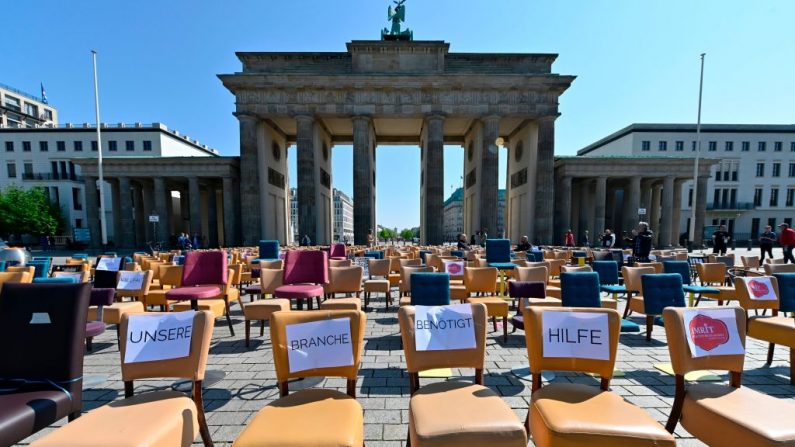 Des chaises vides avec des notes disant "Notre entreprise a besoin d'aide" se trouvent devant la Porte de Brandebourg, un point de repère de Berlin, lors d'une manifestation de gastronomes le 24 avril 2020 au milieu de la pandémie du nouveau coronavirus COVID-19. - Des restaurateurs de tout le pays ont participé à la manifestation intitulée "Leere Stuehle" (chaises vides) organisée par le Club des leaders du réseau des restaurateurs et mise en scène dans plusieurs villes allemandes avec des actions similaires.  (Photo by JOHN MACDOUGALL/AFP via Getty Images)