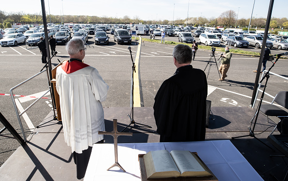 -Le pasteur Frank Heidkamp et Heinrich Fucks se tiennent sur une tribune après un service de Pâques en plein air dans un cinéma drive-in le 10 avril 2020 à Düsseldorf, en Allemagne. Photo de Lars Baron / Getty Images.