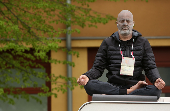 -Un homme tente de montrer qu'il est pacifique en méditant alors qu'il manifeste contre les restrictions à la vie publique visant à endiguer la propagation du coronavirus, ou COVID-19, le 25 avril 2020 à Berlin, Allemagne. Photo par Adam Berry / Getty Images.