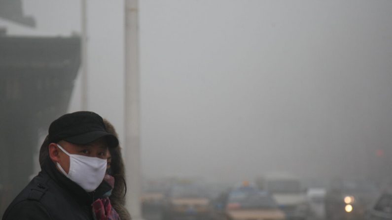 Des piétons marchent le long d'une route alors qu'un épais smog engloutit la ville de Harbin, en Chine, le 3 décembre 2013. (Getty Images)
