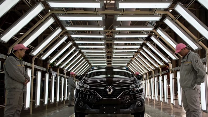 Des ouvriers chinois à côté d'une voiture Kadjar sur la ligne de production du groupe industriel Renault français et Dongfeng chinois à Wuhan, en Chine, le 1er février 2016. (Johannes Eisele/AFP/Getty Images)