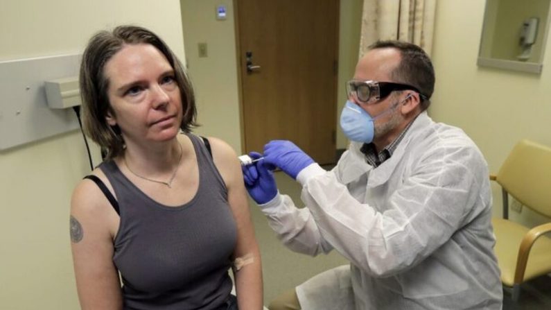 Un pharmacien administre à Jennifer Haller, la première dose de l'essai clinique réalisé lors de la première phase de l'étude de sécurité sur un vaccin possible contre le COVID-19, la maladie causée par le nouveau coronavirus, au centre de recherche sanitaire Kaiser Permanente Washington à Seattle, le 16 mars 2020. (Ted S. Warren/AP Photo)