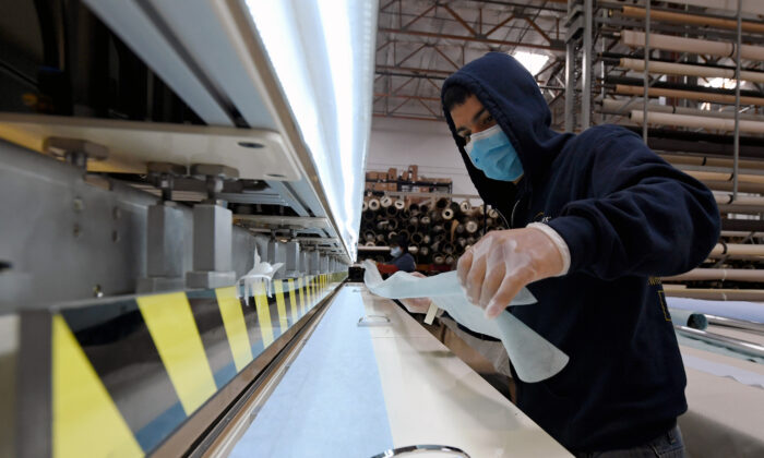 Johnny Diaz fabrique des masques chirurgicaux en tissu de polypropylène filé-lié en utilisant un soudeur à impulsion chez Polar Shades Sun Control à Las Vegas, Nevada. (Ethan Miller/Getty Images)