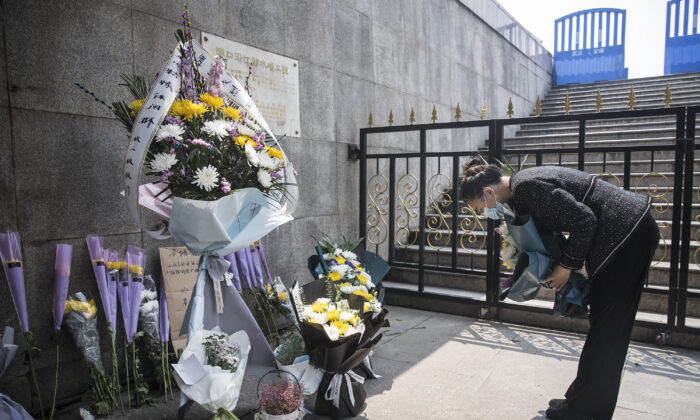 Une résidente offre des fleurs lors d'un hommage silencieux aux martyrs morts dans le combat contre l'épidémie de la nouvelle maladie à coronavirus (covid-19) ainsi qu'aux compatriotes morts de cette maladie à Wuhan, dans la province de Hubei, en Chine, le 4 avril 2020. (Getty Images)