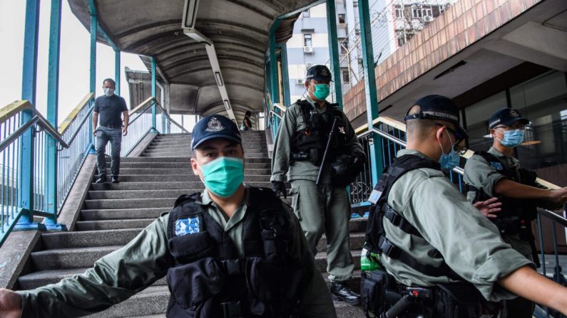 La police anti-émeute a établi un ruban de police près d'un groupe de manifestants pro-démocratie (non photographiés) lors de leur trajet entre l'extérieur du poste de police ouest et le bureau de liaison chinois à Hong Kong, le 22 mai 2020. (Anthony Wallace/AFP via Getty Images)