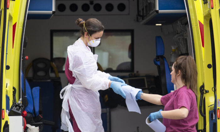 Une employée de l'hôpital nettoie une ambulance devant l'hôpital St. Thomas à Londres, en Angleterre, le 1er avril 2020. (Justin Setterfield/Getty Images)