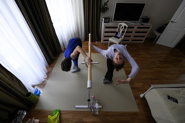 -Au milieu de leur chambre, les danseurs de ballet du Bolchoï Margarita Shrainer et Igor Tsvirko ont placé un tapis de linoléum et une barre, à Moscou le 29 avril 2020. Photo de Kirill KUDRYAVTSEV / AFP via Getty Images.