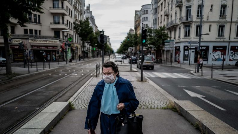 Une femme portant un masque marche dans une rue de Lyon le 11 mai 2020 (Photo by JEFF PACHOUD/AFP via Getty Images)