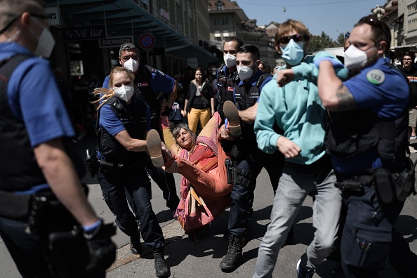 Des manifestants anti-restrictions sont arrêtés par des policiers, à Berne le 16 mai 2020. (Photo : FABRICE COFFRINI/AFP via Getty Images)