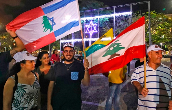 -D'anciens soldats et combattants israéliens de l'Armée du Sud-Liban et leurs proches brandissent le drapeau israélien et libanais lors d'un rassemblement sur la place Rabin à Tel Aviv le 23 mai 2020, pour commémorer vingt ans depuis leur retrait du Liban. Photo de JACK GUEZ / AFP via Getty Images.