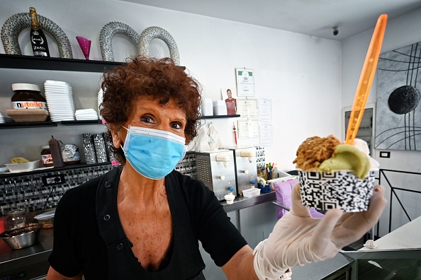 -Maddalena sert une crème glacée à un client au glacier Brivido dans le quartier Testaccio de Rome le 26 mai 2020. Photo par Alberto PIZZOLI / AFP via Getty Images.