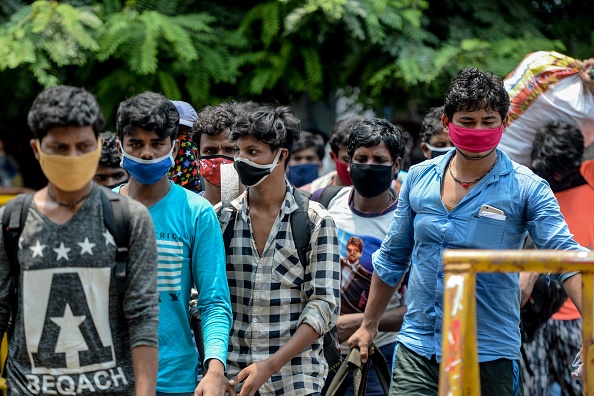 Les travailleurs migrants se rassemblent pour être transférés à une gare pour monter à bord d'un train spécial vers l'État du Bihar après que le gouvernement a assoupli un confinement national imposé à titre préventif contre le COVID-19, à Chennai le 27 mai , 2020. (Photo : ARUN SANKAR/AFP via Getty Images)