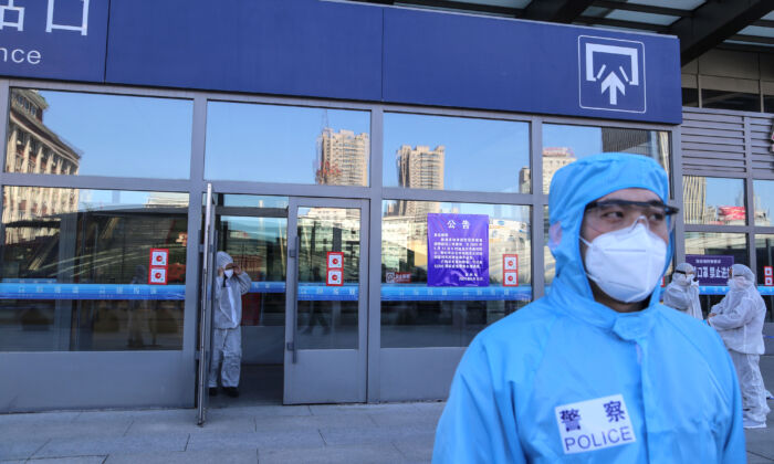 Des policiers vêtus de combinaisons de protection montent la garde devant la gare de la ville de Jilin, dans la province chinoise de Jilin, le 13 mai 2020. (STR/AFP via Getty Images)